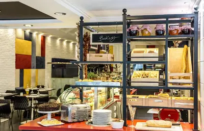 a bakery with a shelf with food on it at Airotel Alexandros in Athens