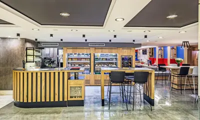 a restaurant with a bar with stools at Airotel Alexandros in Athens
