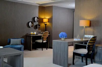 a waiting room with chairs and a desk and tables at Airotel Alexandros in Athens