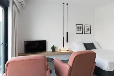 a bedroom with two chairs and a bed and a tv at Voda Luxury Residence Penthouse #601 - Acropolis View Rooftop in Athens