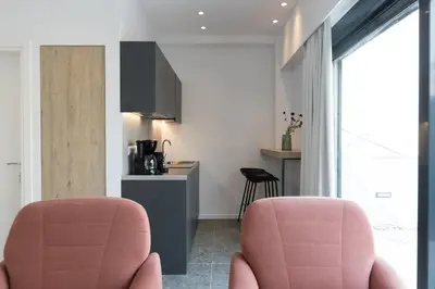 two pink chairs in a room with a kitchen at Voda Luxury Residence Penthouse #601 - Acropolis View Rooftop in Athens