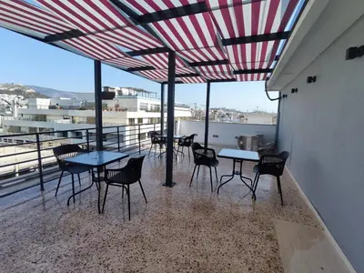 a patio with tables and chairs on a balcony at Voda Luxury Residence Penthouse #602 - Acropolis View Rooftop in Athens