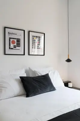a bedroom with a white bed with two pictures on the wall at Voda Luxury Residence Penthouse #602 - Acropolis View Rooftop in Athens