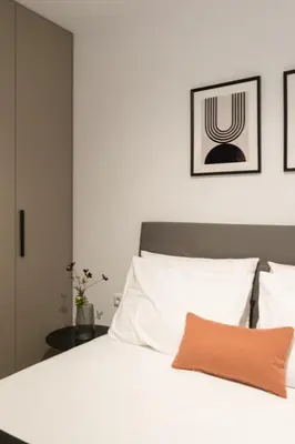 a bedroom with a white bed with an orange pillow at Voda Luxury Residence #801 - Acropolis View Rooftop in Athens