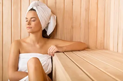 a woman sitting in a sauna with a towel on her head at Emmantina Hotel in Athens