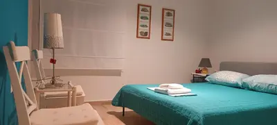 a bedroom with a bed with a green bedspread and a chair at B2 Acropolis in Athens