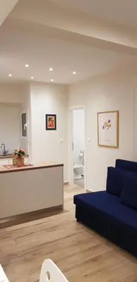 a living room with a blue couch and a kitchen at B2 Acropolis in Athens