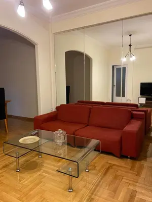 a living room with a red couch and a glass table at Elegant Apartment in Athens