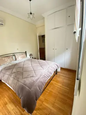 a bedroom with a large bed and a wooden floor at Elegant Apartment in Athens