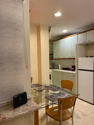 a kitchen with a glass table and a white refrigerator at Elegant Apartment in Athens