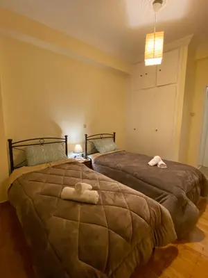 a bedroom with two beds with towels on them at Elegant Apartment in Athens
