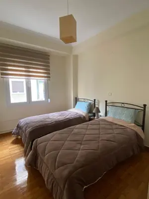 a bedroom with two beds and a ceiling at Elegant Apartment in Athens