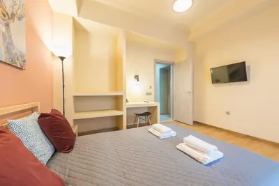 a bedroom with a bed and a desk and a television at Rest Sleep Repeat by museum-2 in Athens