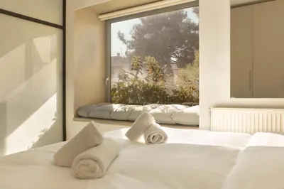 a bedroom with a white bed with towels on it at Luxury Apt with Parking-Living Stone Silver in Athens
