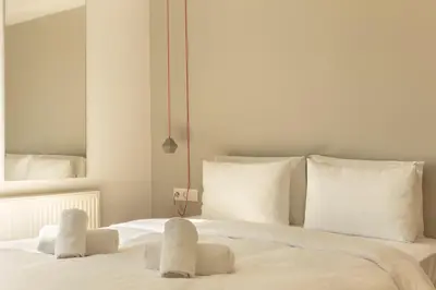 a white bed with two white towels on it at Luxury Apt with Parking-Living Stone Silver in Athens