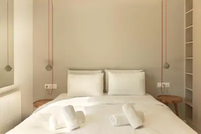 a white bed with two white towels on it at Luxury Apt with Parking-Living Stone Silver in Athens
