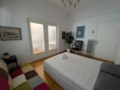 a bedroom with a white bed and a window at Spacious 2BA next to the park and Archeological museum in Athens