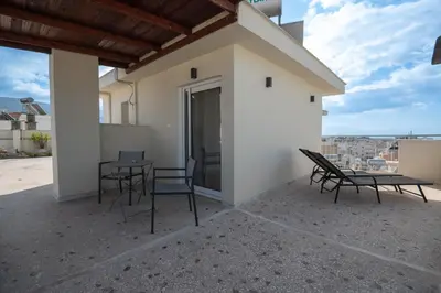 a patio with two chairs and a table on a building at Studio with panoramic Athens view in Athens