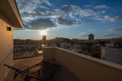 a balcony with two chairs and a view of a city at Studio with panoramic Athens view in Athens