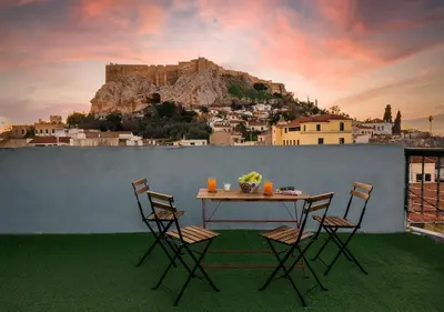 a table and chairs on a balcony with a mountain at Plaka Apartment With Terrace View in Athens