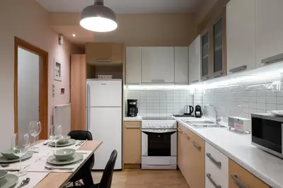 a kitchen with a table and a white refrigerator at Plaka Apartment With Terrace View in Athens