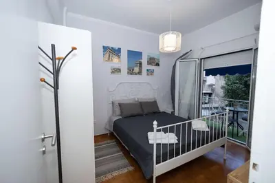 a small bedroom with a bed and a balcony at ΑΙΘΡΑ Suite in Athens