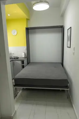 a bedroom with a bed in the corner of a room at ΑΙΘΡΑ Suite in Athens