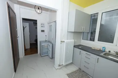 a kitchen with white cabinets and a sink at ΑΙΘΡΑ Suite in Athens