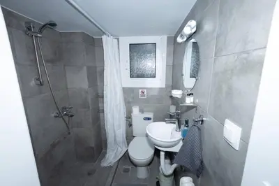a bathroom with a shower and a toilet and a sink at ΑΙΘΡΑ Suite in Athens