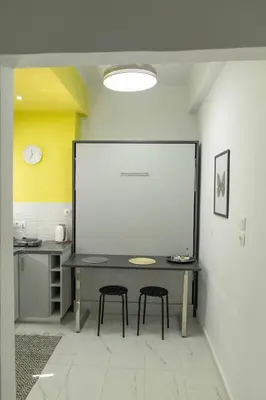 a room with a table and two stools at ΑΙΘΡΑ Suite in Athens