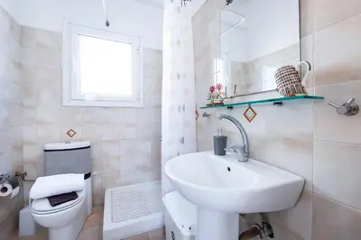 a white bathroom with a sink and a toilet at Loft Apt with Acropolis View in Athens