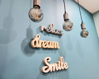 a dream smile sign on a blue wall with lights at Victoria Suite VIPGreece in Athens