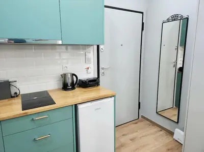 a small kitchen with blue cabinets and a mirror at Victoria Suite VIPGreece in Athens