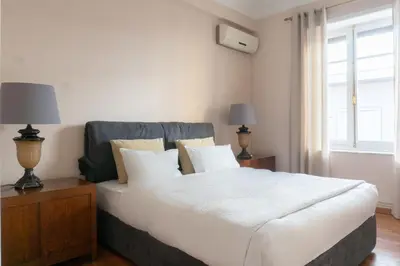 a bedroom with a large white bed and a window at Hadrians Den in Heart of Plaka by JJ Hospitality in Athens