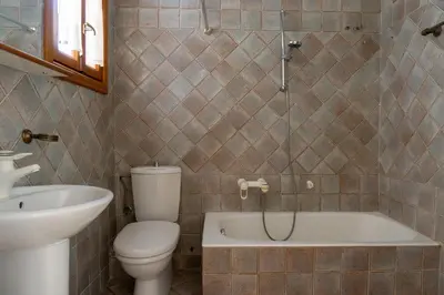 a bathroom with a toilet and a tub and a sink at Hadrians Den in Heart of Plaka by JJ Hospitality in Athens