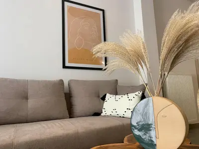 a living room with a couch and a table with a vase at Anneta’s home in Athens