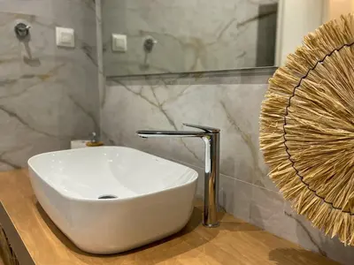 a white sink sitting on a counter in a bathroom at Anneta’s home in Athens