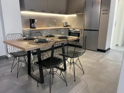 a kitchen with a table with chairs and a refrigerator at Anneta’s home in Athens