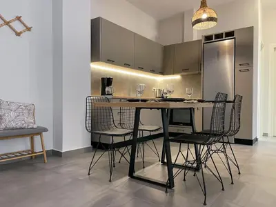 a kitchen with a table with chairs and a refrigerator at Anneta’s home in Athens