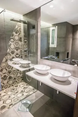 a bathroom with three sinks and a mirror at Palmyra Beach Hotel in Athens