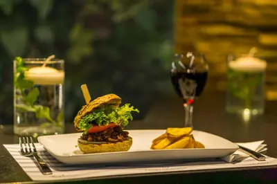a sandwich and chips on a plate with a glass of wine at Palmyra Beach Hotel in Athens