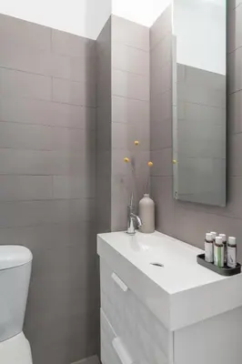 a bathroom with a sink and a toilet and a mirror at Foothills of Acropolis-Thissio 3 bdrm apartment in Athens