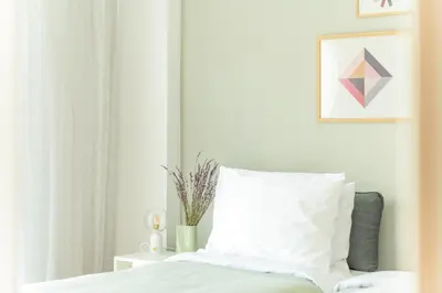 a bedroom with a bed with a white pillow at Foothills of Acropolis-Thissio 3 bdrm apartment in Athens