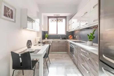 a kitchen with a white table and chairs and a refrigerator at Foothills of Acropolis-Thissio 3 bdrm apartment in Athens