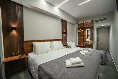 a bedroom with a large bed with towels on it at Argo Hotel Piraeus in Piraeus