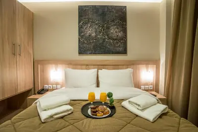 a bedroom with a bed with a tray of food on it at Argo Hotel Piraeus in Piraeus
