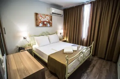 a small bedroom with a bed and a window at Argo Hotel Piraeus in Piraeus