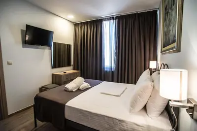 a hotel room with a bed and a television at Argo Hotel Piraeus in Piraeus