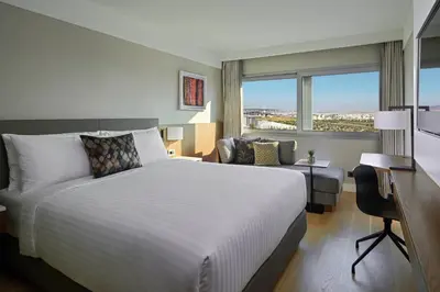 a hotel room with a large bed and a chair at Athens Marriott Hotel in Athens