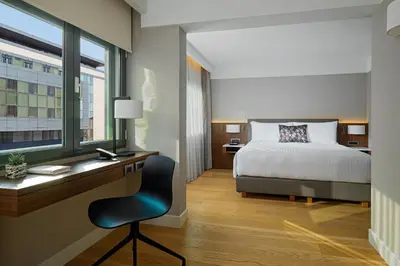 a bedroom with a bed and a desk with a chair at Athens Marriott Hotel in Athens